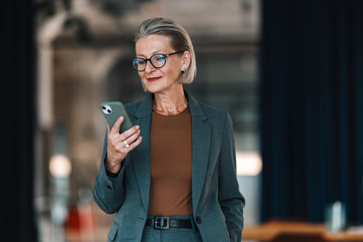 Portrait Of A Senior Business Woman Using Her Mobile At The Office